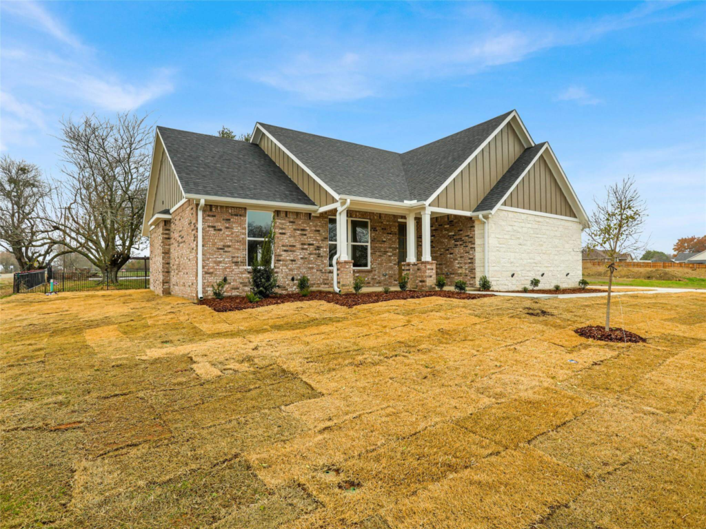 A completed custom new construction home in the DFW area by Northwood Homes, showcasing high-quality stone and brick exteriors.