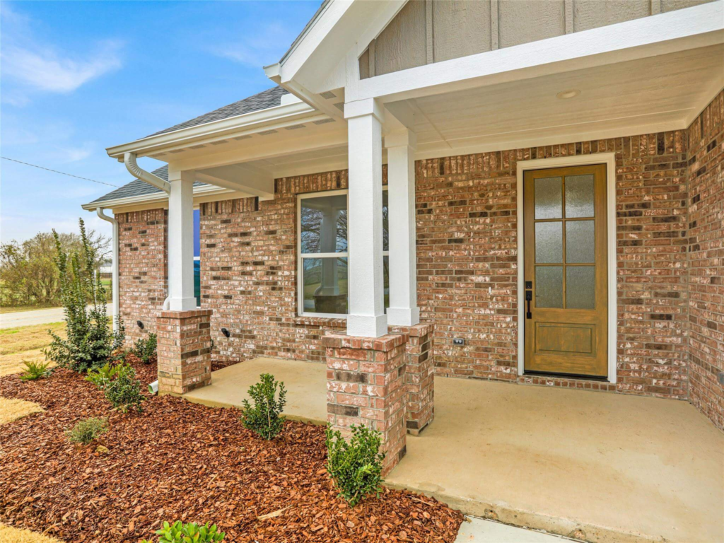 Exterior view of the Westlake Home, a custom-built residence built by Northwood Homes featuring traditional brickwork, a craftsman-style porch, and high-end finishes.