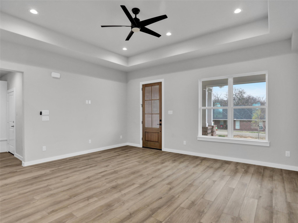 A Northwood Homes custom interior featuring a modern tray ceiling, recessed lighting, and open-concept flooring in a DFW new construction.