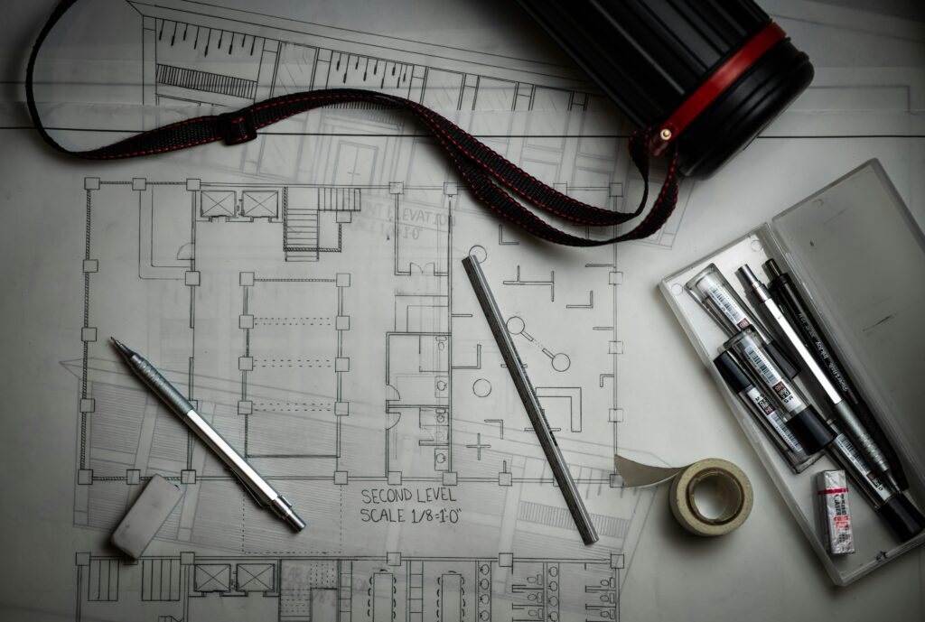 Detailed architectural blueprints and drafting tools used for designing custom home floor plans.